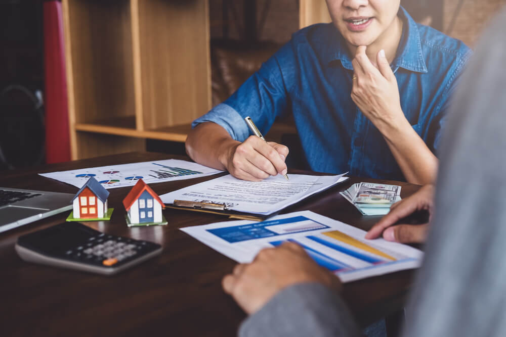 a person signing papers in the home owning process.